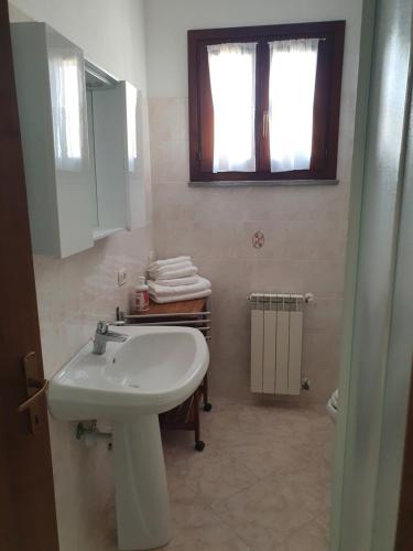 卡波利韦里Mare Fuori Lacona的一间带水槽和卫生间的浴室以及窗户。