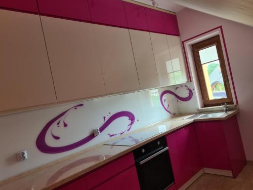 GolczowiceMARMI Noclegi的厨房配有紫色和白色的橱柜和窗户