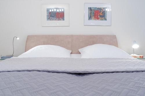蒂门多弗施特兰德Haus Eva Mar am Meer Appartement 7的一张带白色床单和枕头的床