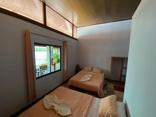 托尔图格罗Hotel Sunset Rooms的客房设有两张床和窗户。