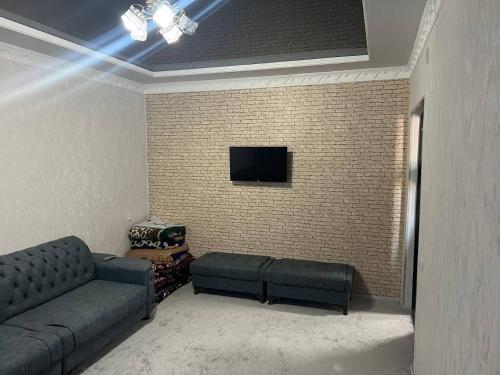 希瓦Ancient Khiva Apartment的带沙发和砖墙的客厅