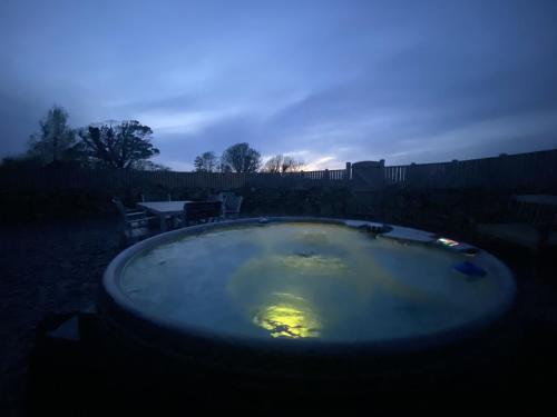 德维兰Peibio at Llanfair Hall的晚上在院子里设有热水浴池