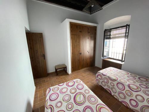 贝赫尔-德拉弗龙特拉Mayorazgo的一间卧室设有两张床和窗户。