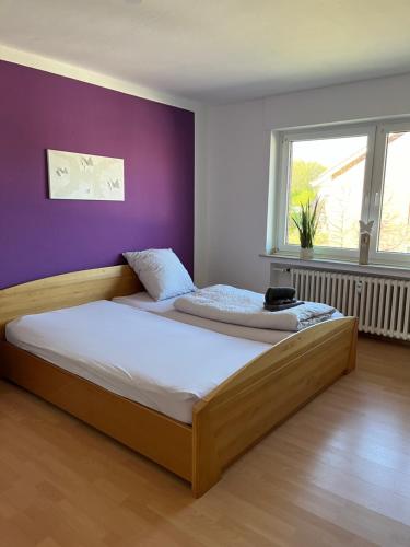 利珀河畔的韦尔纳Apartment Geronimo的一间卧室配有一张带紫色墙壁的木床