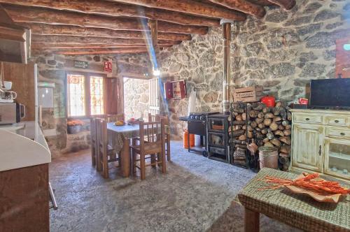 Villar de Cornejacasa rural La Fragua的厨房配有桌子和炉灶。