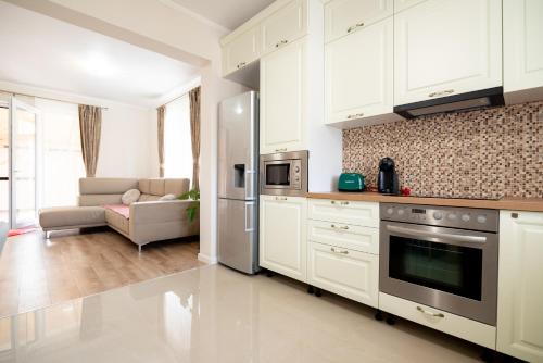 奥拉迪亚Casa de langa lac的厨房配有白色橱柜和不锈钢冰箱