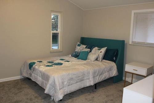 托莱多NEW Bright & Modern 3BR// Conveniently Located//Toledo Stones Throw的一间卧室配有一张带绿色床头板的床