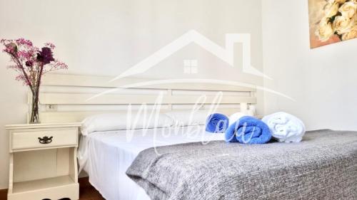 卡拉布兰卡SA TORRETA 4的一间卧室配有床和带毛巾的床头柜。
