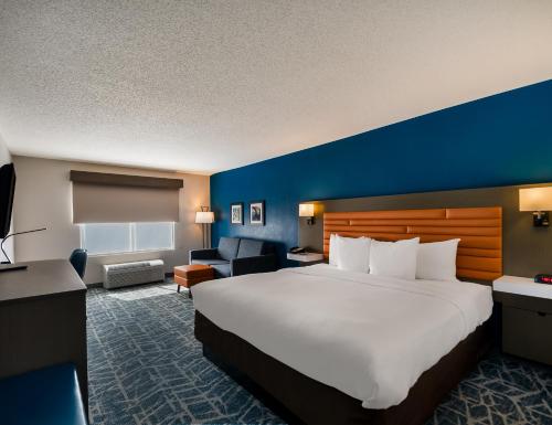 福尔斯彻奇Comfort Inn Falls Church - Tysons Corner的酒店客房设有一张大床和蓝色的墙壁。