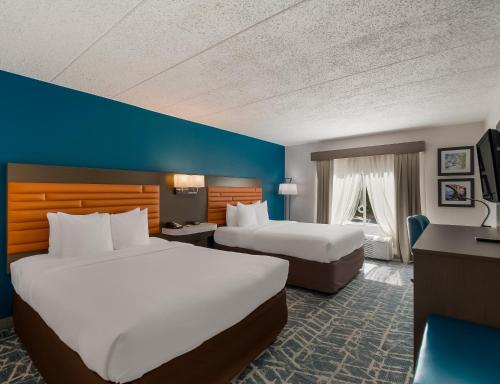 福尔斯彻奇Comfort Inn Falls Church - Tysons Corner的酒店客房配有两张床和一张书桌