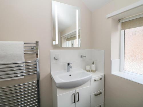 阿什伯恩Kennedy's Cottage的白色的浴室设有水槽和镜子