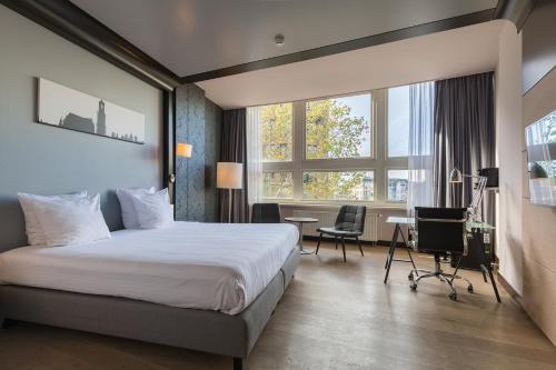 乌得勒支Leonardo Hotel Utrecht City Center的酒店客房设有一张床、一张书桌和窗户。