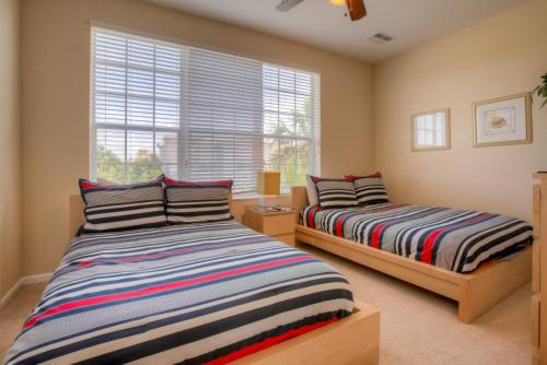 奥兰多Resort Townhome: Perfect Orlando Vacation Spot的一间卧室设有两张床和窗户。