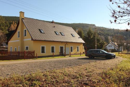 奥斯特鲁兹纳Apartment Ostružná的停在黄色房子前面的一辆黑色汽车