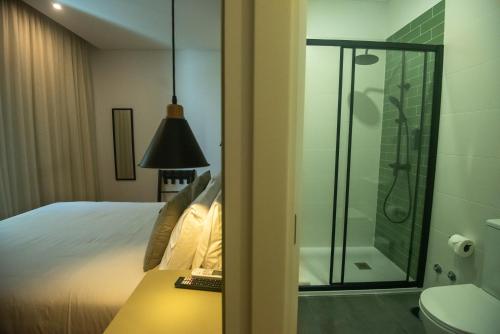 坎普自由鎮Olive Boutique Guesthouse的浴室设有床铺和玻璃淋浴间。