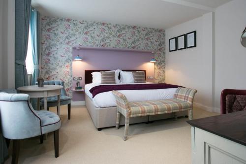 德比农园酒店的卧室配有1张床、1张桌子和1把椅子