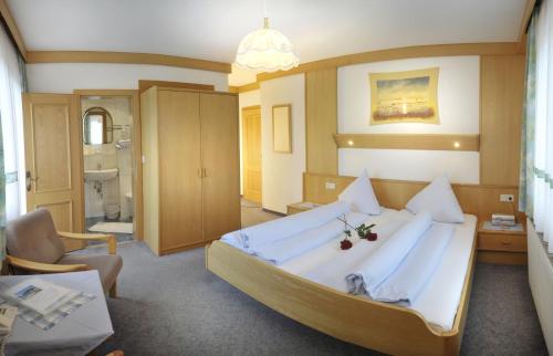 拉姆绍达赫斯坦阿尔卑巴特酒店的大卧室配有一张带白色床单的大床
