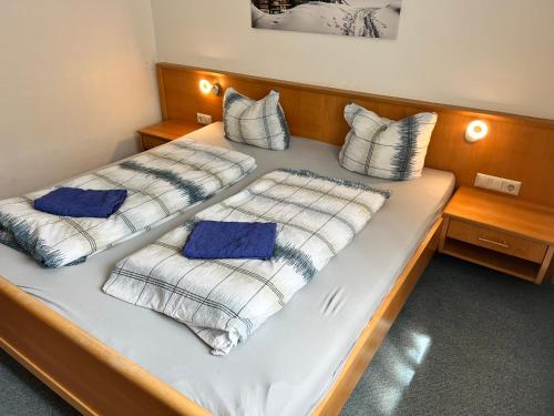 弗拉塔赫Haus Gletscherblick的一张带白色床单和蓝色枕头的床