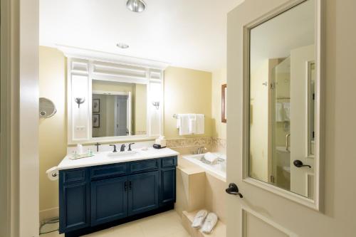 希尔顿黑德岛海港镇度假村和俱乐部的浴室设有蓝色水槽和镜子