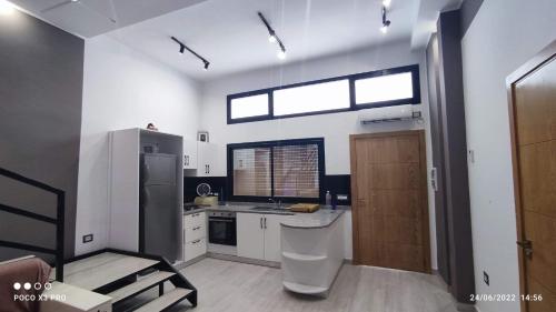 古莱比耶Kelibia beach luxury maison的厨房配有水槽、冰箱和窗户。