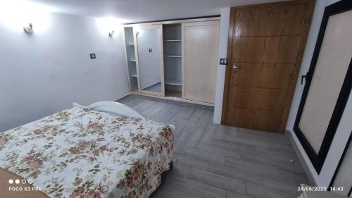 古莱比耶Kelibia beach luxury maison的一间卧室配有一张床和一个木制橱柜
