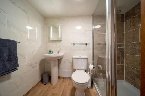 林顿Coachman's Quarters的浴室配有卫生间、盥洗盆和淋浴。