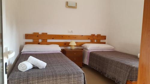 圣费兰-德瑟斯罗CASA PATY, Estudio rural. Sant Ferran FORMENTERA的一间卧室配有两张床和一张带台灯的桌子