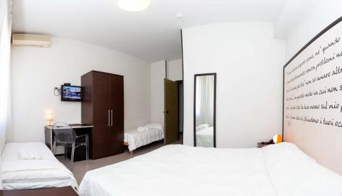 西维尔诺瓦·马尔凯日光浴酒店 的一间卧室配有两张床、一张桌子和一面镜子