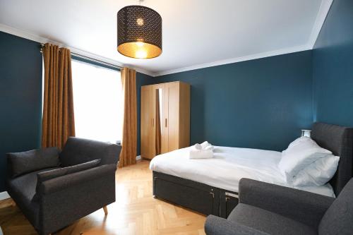 爱丁堡Spacious 4BR City Centre Apartment w/ Free Parking的一间卧室配有一张床、一把椅子和一张沙发