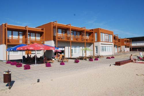 沃鲁Hotell Tamula的海滩上的一座建筑,配有桌子和遮阳伞