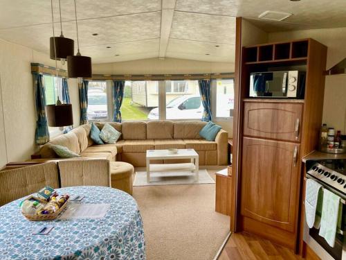 赫尔斯顿Cornish Caravan on The Lizard Peninsula, Cornwall.的客厅配有沙发和大篷车内的桌子
