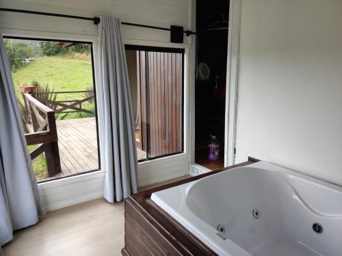 乌鲁比西Hospedaria Kayser Haus的带浴缸的浴室和大窗户