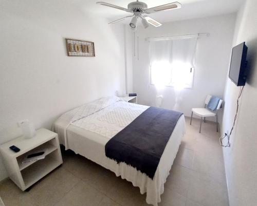 圭马尔港Disfruta en 1ª línea de playa的一间卧室配有一张床和吊扇