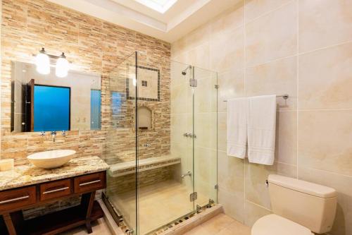 普拉亚埃尔莫萨Casa Ilan Ilan的一间带玻璃淋浴和水槽的浴室