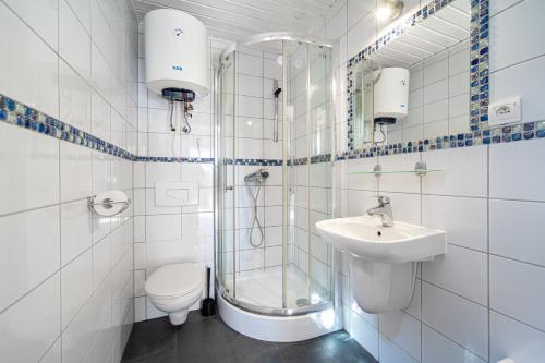 米泽德沃兹Błękitne domki przy morzu的带淋浴、卫生间和盥洗盆的浴室