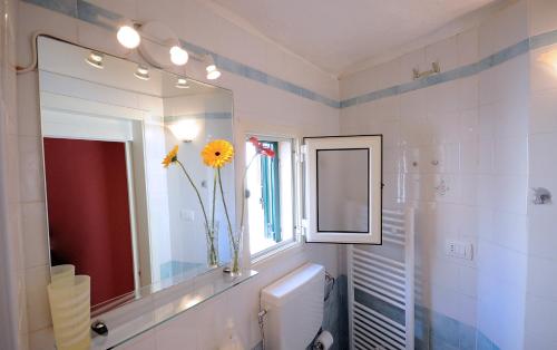 加利波利Palazzo Rocci Rooms的浴室设有镜子和带向日葵的花瓶