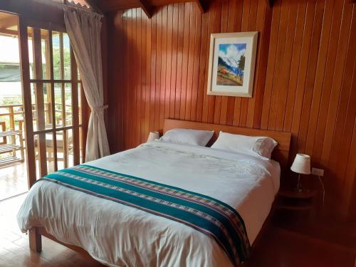 奥克萨潘帕Chontaqui Eco-Lodge的一间卧室配有一张木墙床
