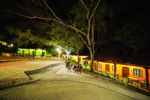 El MolinoLa Arboleda Colonial Hotel的一群人晚上坐在公园的长椅上