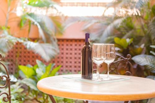 圣何塞德尔卡沃HOTEL COLLI的桌子上放有一瓶葡萄酒和两杯酒