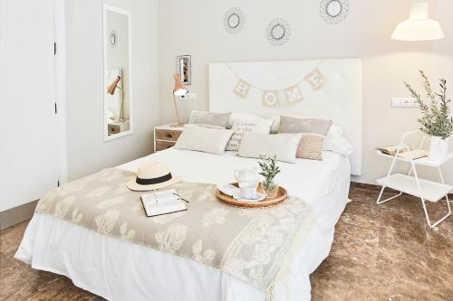福恩吉罗拉Villa in Fuengirola Center NEW SALT WATER POOL的一间白色的卧室,配有一张带帽子的床