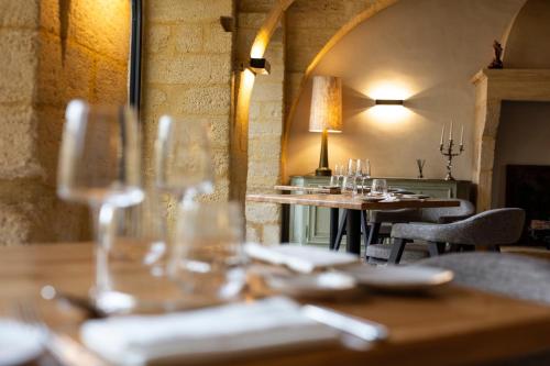 ColliasChâteau de Collias的配有桌椅和酒杯的餐厅