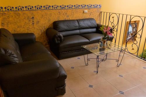 NaolincoHotel del Parque Naolinco的客厅配有真皮沙发和桌子