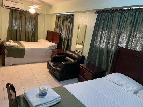 圣多明各托雷斯公寓式酒店的酒店客房带两张床和真皮座椅。