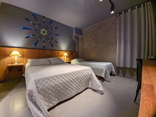 马利西亚斯Villa'l Mare Hotel的一间卧室设有两张床,墙上挂着一个时钟。