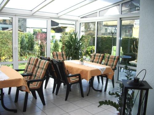 策尔廷根-拉蒂希Gästehaus Resi的庭院中设有温室,配有桌椅