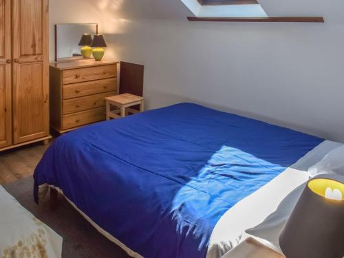 波斯科诺25 Mallard Cottage- Uk38932的卧室配有蓝色和白色的床和梳妆台。