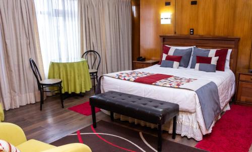 洛斯安赫莱斯Hotel Gran Muso的一间卧室配有一张大床和椅子