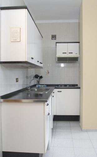 塔马达斯特布姆兰二号公寓的厨房配有白色橱柜和水槽