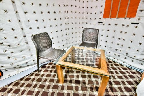 帕哈尔加姆The Posh Camps的墙上的星星间里设有两把椅子和一张桌子
