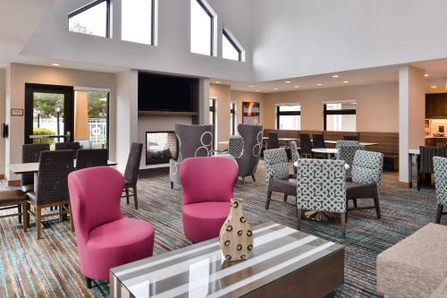 博伊西博伊西市中心/大学原住客栈酒店的一间设有粉红色椅子和桌子的等候室